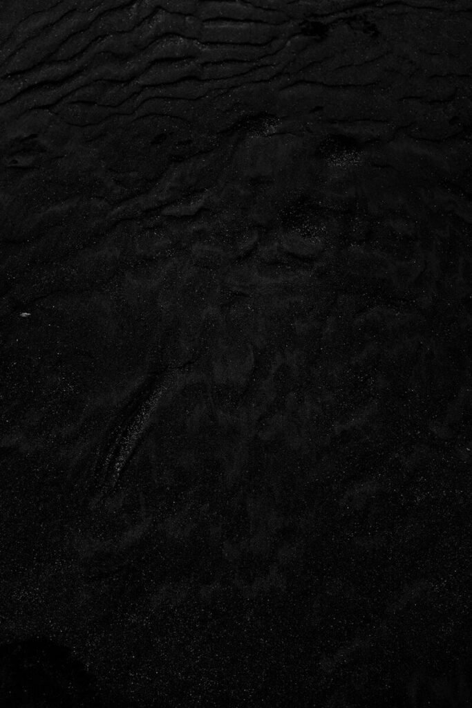 a black and white photo of water and sand